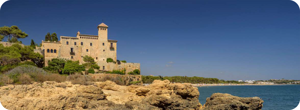 Romaans kasteel Castell de Tamarit op een rotspartij aan de Middellandse Zee onder een strakblauwe hemel in Spanje