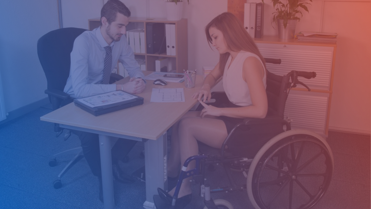 Man en vrouw in gesprek op kantoor de vrouw zit in een rolstoel expert op blauw rode achtergrond