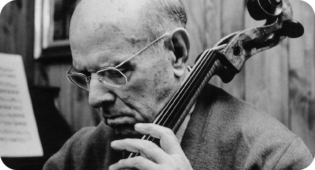 Zwart-witfoto van de oudere Catalaanse cellist Pablo Casals, van opzij gezien, geconcentreerd kijkend terwijl hij zijn cello bespeelt