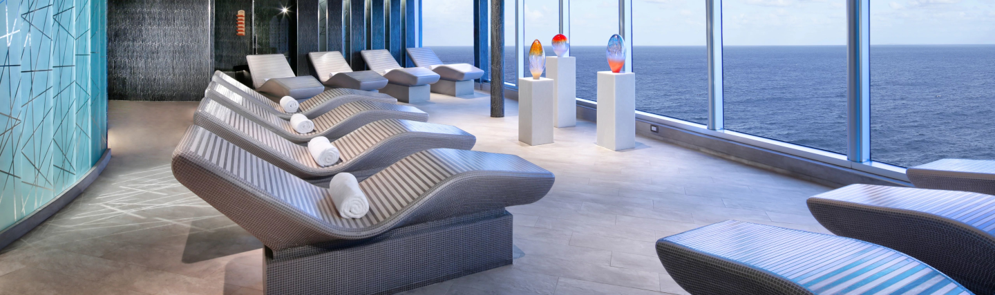 Ontspannende spa-ruimte met thermaalbad, verwarmde ligstoelen en zeezicht aan boord van Holland America Line.