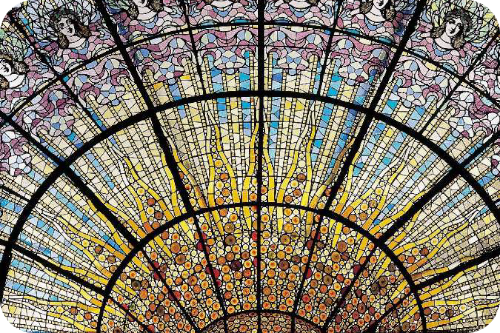 Een omgekeerde koepel van kleurrijk glas-in-lood in het plafond van het Palau de la Música Catalana, met in het midden een gouden zon omringd door gezichten van vrouwen.