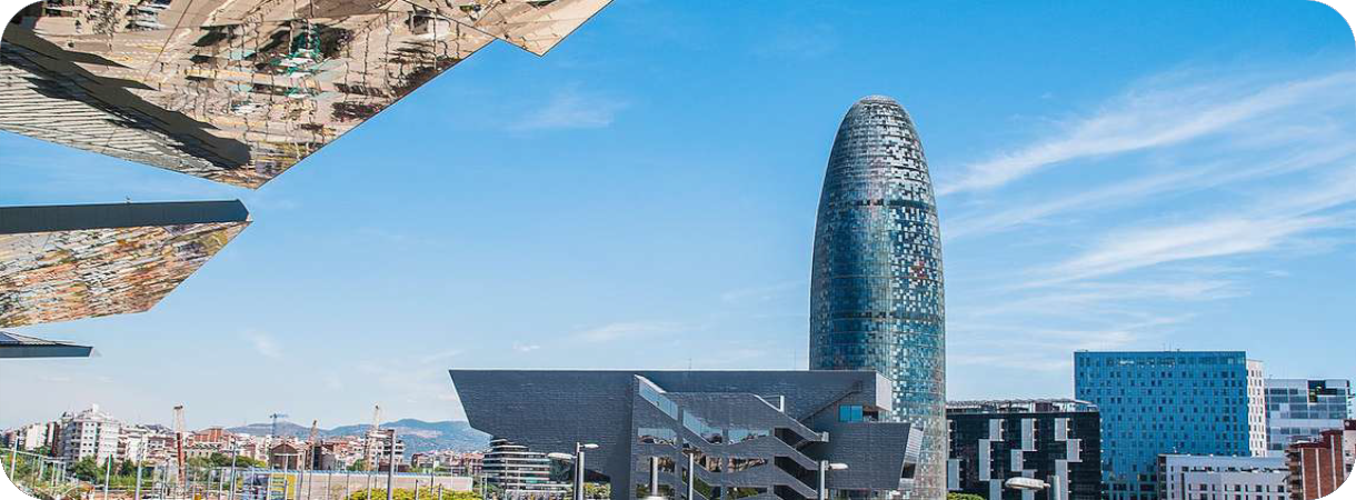 De moderne Torre Glòries wolkenkrabber en het Design Museum in Barcelona onder een strakblauwe hemel.