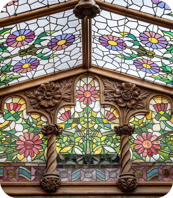 Kleurrijk glas-in-lood met bloemmotieven in een houten omlijsting, typerend voor het Catalaans modernisme in Casa Navàs.