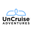 Logo van UnCruise Adventures met een gestileerd silhouet van een schip en zon boven de merknaam in robuuste letters op een witte achtergrond.