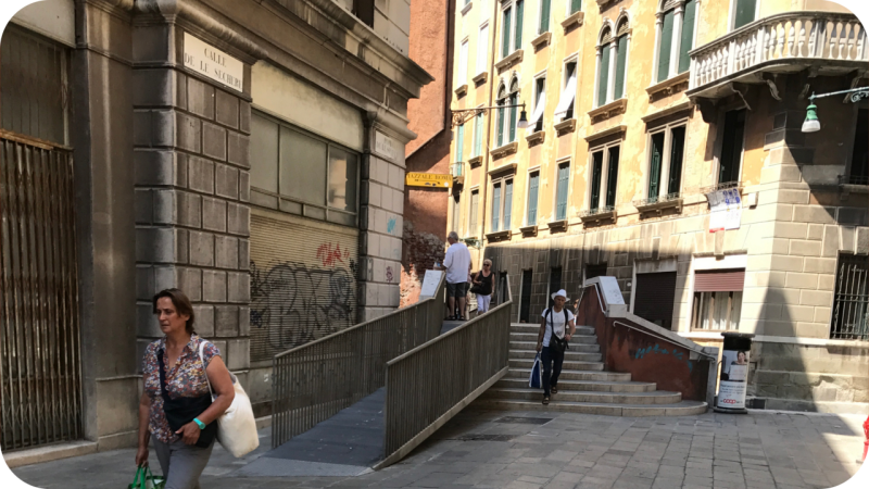 Ponte de le Sechere in Venetië, waarbij een lange, metalen hellingbaan over de vaste traptreden van de stenen brug is geplaatst voor betere toegankelijkheid
