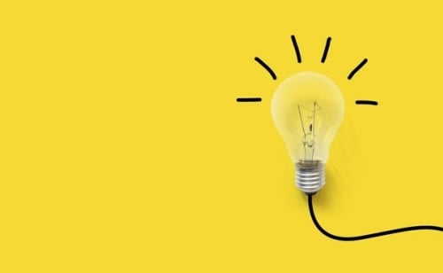 Gloeilamp tegen gele achtergrond