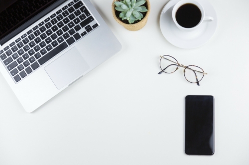 Laptop, mobiel, bril en kop koffie