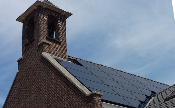 Zonnestroominstallatie met Trienergia zonnepanelen op een driehoekig dak van oude kerk