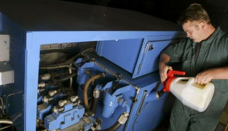 Worker applying oils or to machinery