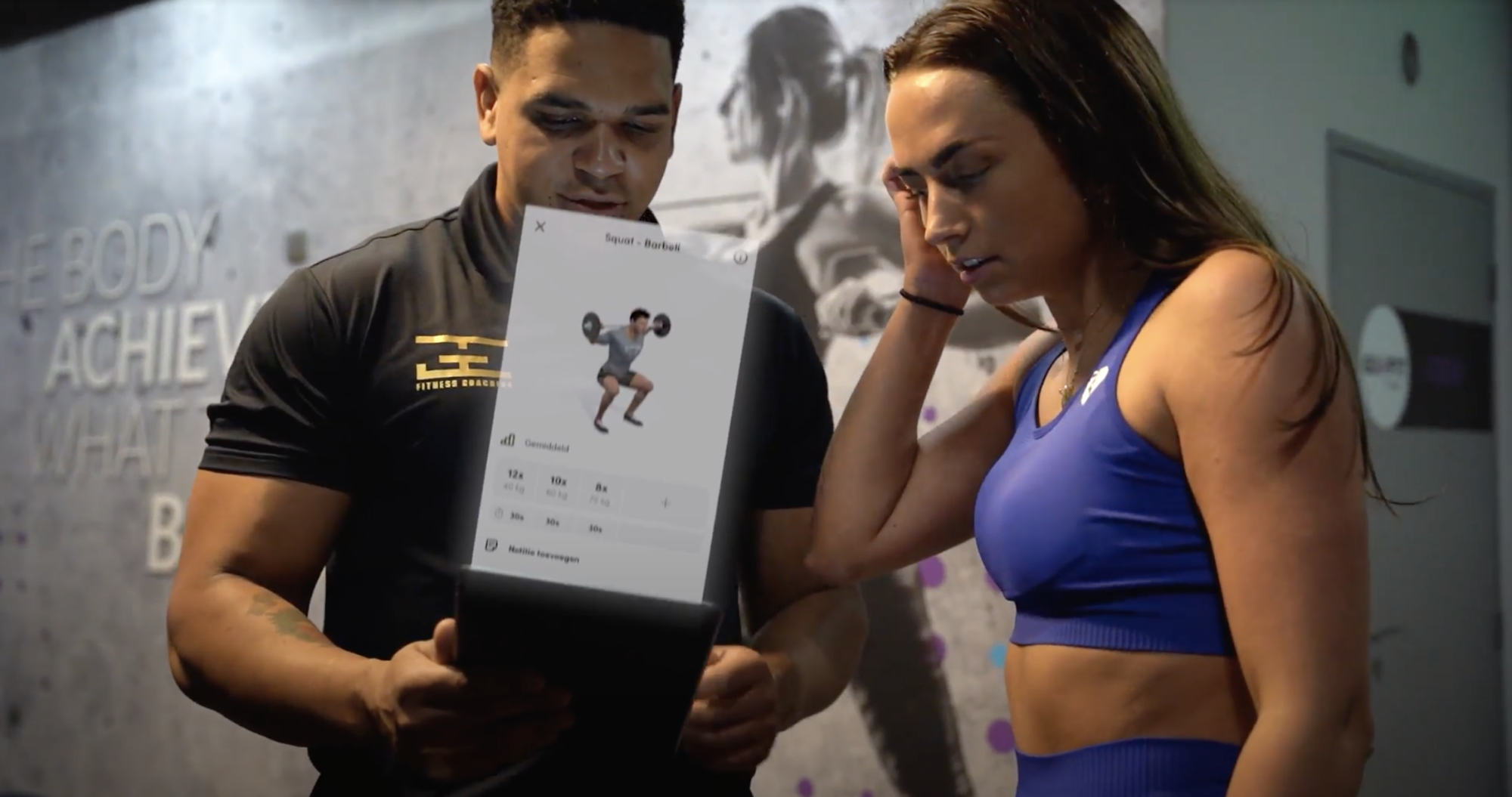 Galbin Espinosa legt een coaching klant uit hoe zijn Fitness app werkt