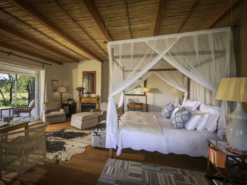 samara-karoo-lodge-bedroom-area-and-seating-area-with-fireplace