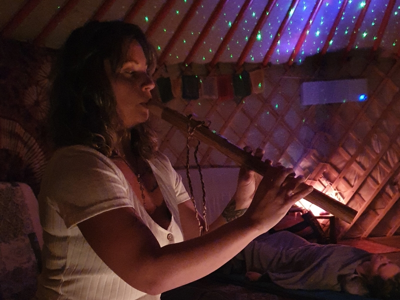 Alicia in de sfeervolle yurt bespeelt de fluit