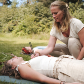 Vrouw doet met stemvork op hartchakra soundhealing