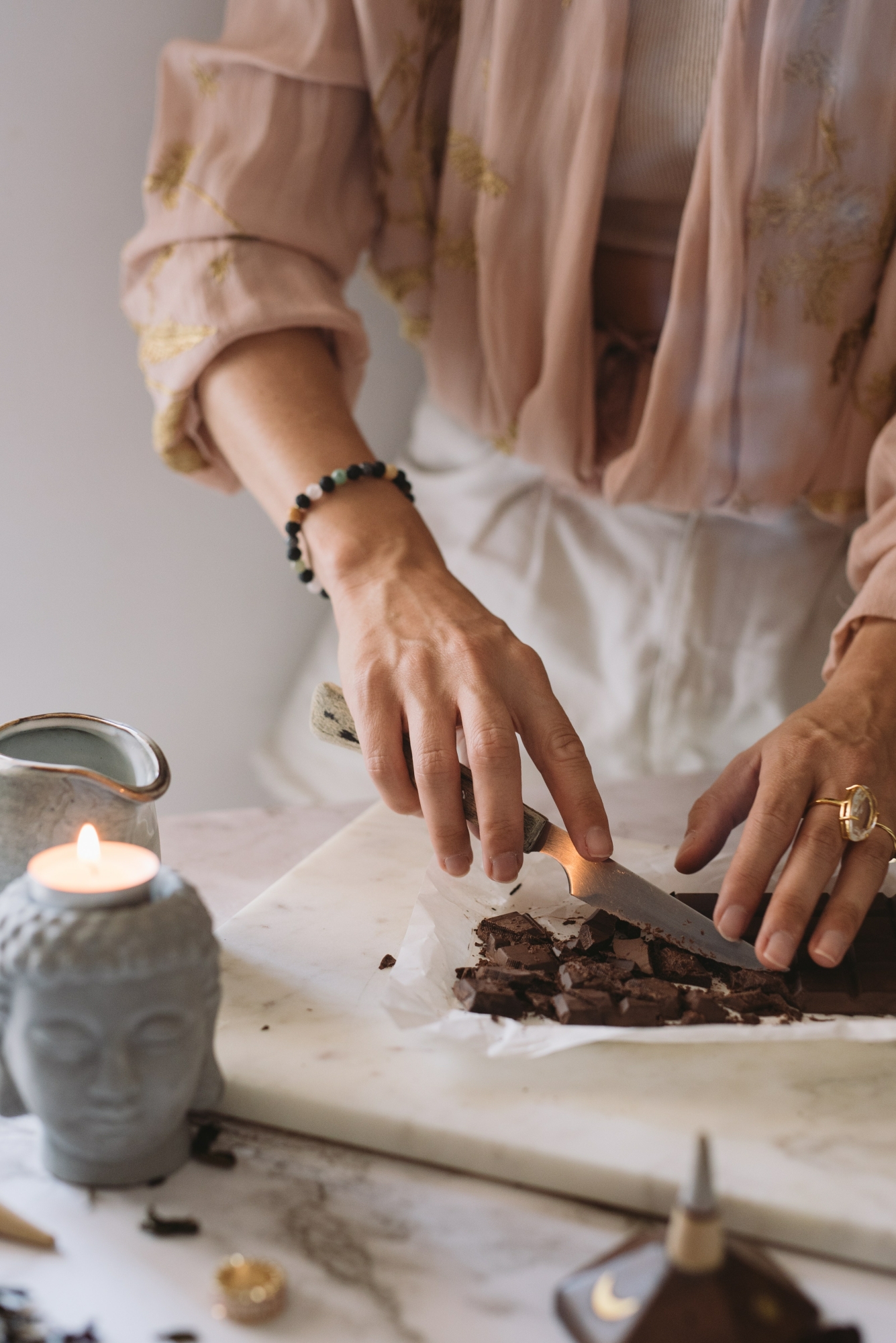 Vrouw maakt blok cacao klein met mes