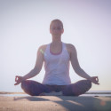 Marjolein Groen in meditatiehouding op het strand