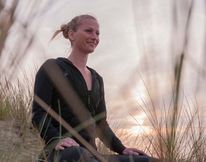 Marjolein Groen, Yogadocent, NLP-coach en hypnotherapeut, zittend in de duinen