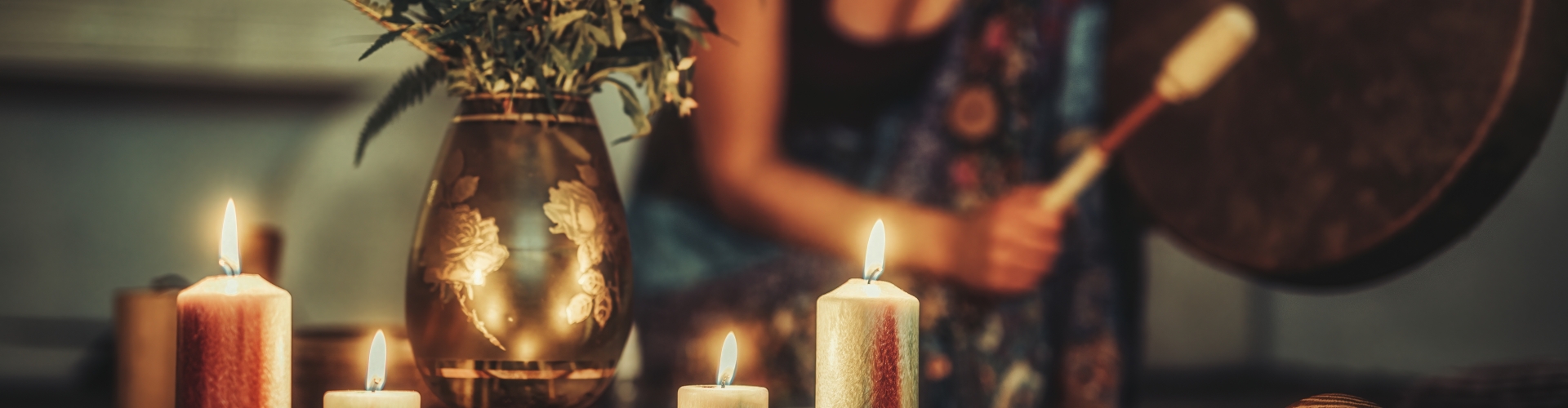 Vrouw drumt rond altaar met kaarsen