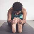Vrouw doet yogahouding - zittende vooroverbuiging - tanghouding - paschimottanasana