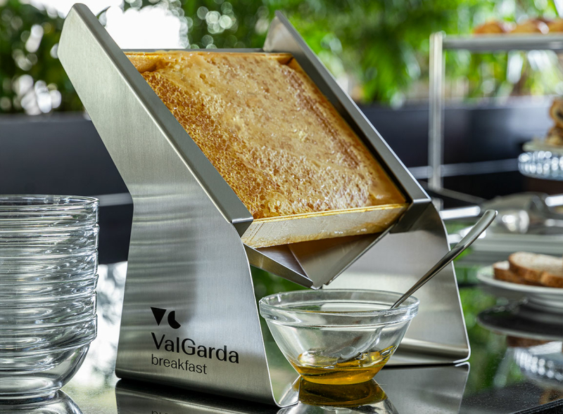 Luxe ontbijtpresentatie met pure honingraat die gasten direct uit de raat kunnen proeven voor een natuurlijke beleving.