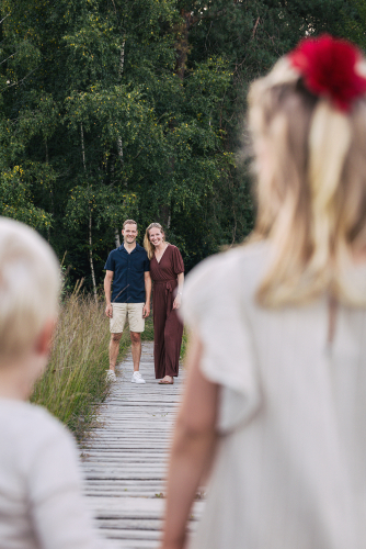 Familiefotografie - Ouders op houten vlonderpad met kinderen op voorgrond - Fotografie Debbie - Barneveld