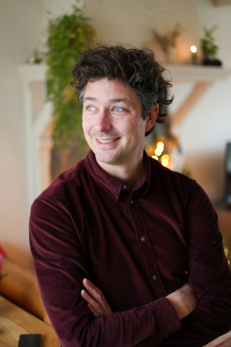 Freek Moerlands, HSP-coach,  zijwaarts lachend in de prijktijkruimtewarme binnenruimte