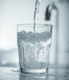Een glas water dat gevuld wordt Een glas water dat gevuld word onder de kraan.