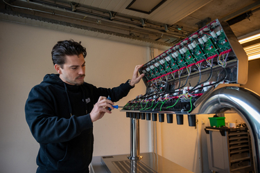 Een postmixmachine wordt onderhouden door een monteur van Grapos