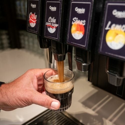 Een glas cola wordt getapt uit een Grapos frisdrankmachine Een glas cola wordt getapt uit een duurzame postmixmachine van Grapos.