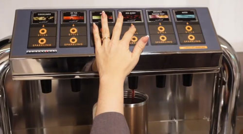 Student vult een drinkfles met gezonde dranken van Grapos Student vult een drinkfles met gezonde dranken van Grapos