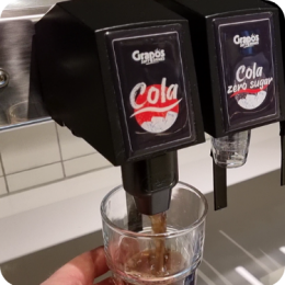 Een glas cola wordt getapt uit een Grapos postmixdispenser Iemand tapt een glas cola uit een duurzame postmixmachine van Grapos.