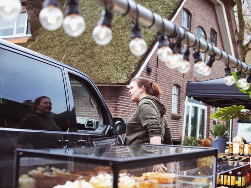 Lisette aan het werk bij een buitenlocatie, ingesprek met een gast, een voorbeeld van haar gastvrije aanpak in de praktijk