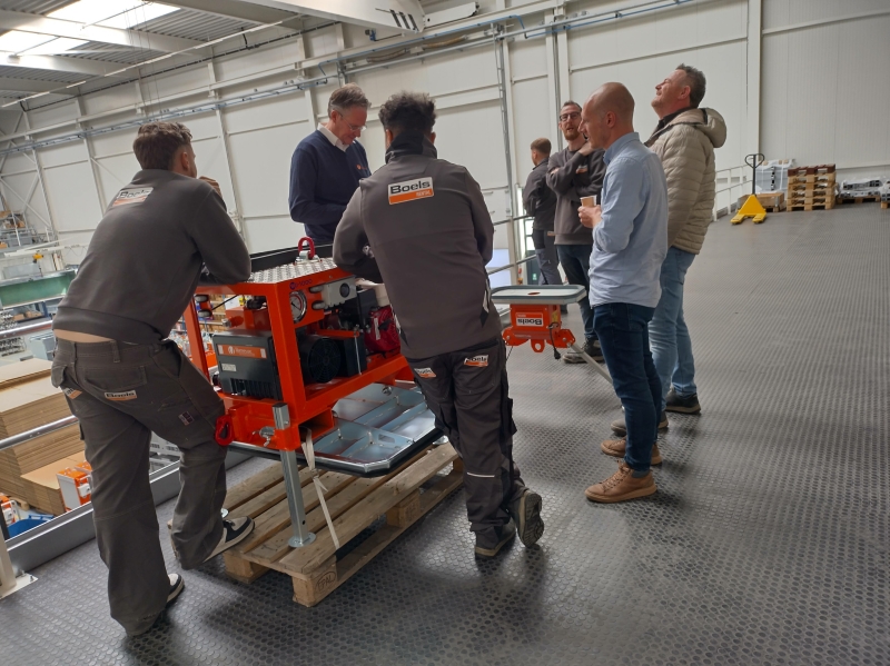 Groep Boels-medewerkers rond oranje Hamevac vacuümunit tijdens praktijksessie bij Hamevac