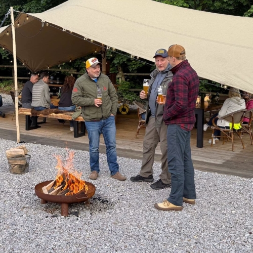 Gasten staan rond het vuur tijdens outdoor cooking bij Harz Hotel Iris in de Harz