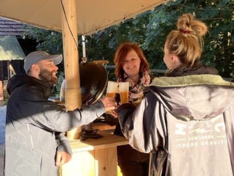 Gasten proosten onder de buitentent tijdens outdoor cooking bij Harz Hotel Iris in de Harz