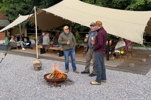 Groep gasten geniet samen bij het vuur tijdens een kook- en belevingsarrangement bij Harz Hotel Iris