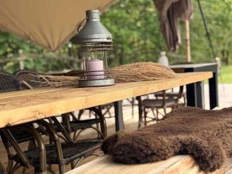 Sfeervolle houten tafel onder de buitentent tijdens outdoor cooking bij Harz Hotel Iris