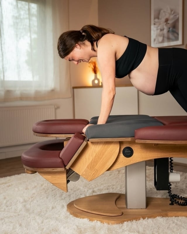 zwangervrouw gaat op massagetafel liggen