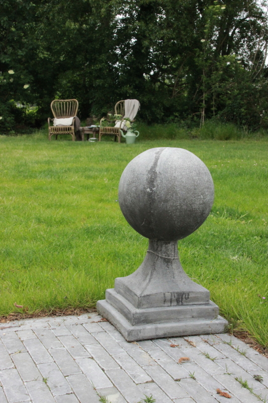 Tuinbeeld bal op voet van beton