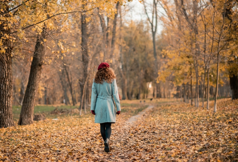 Vrouw loopt door een bos tijdens de herfst