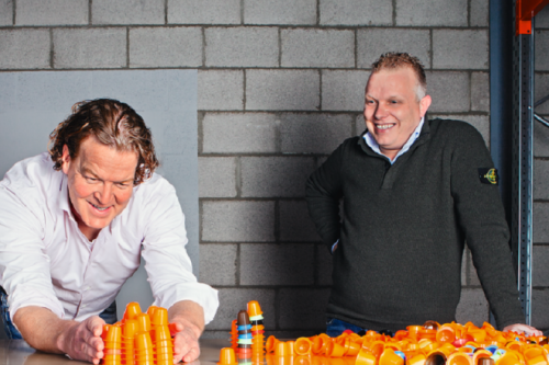 werknemer van eurocaps die een stapel van koffiecups maakt