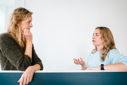 Overleg op kantoor tussen Karin en Suzanne