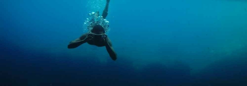 Persoon met camera voor hoofd onderwater