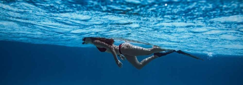 Vrouw met snorkel en duikbril onder water