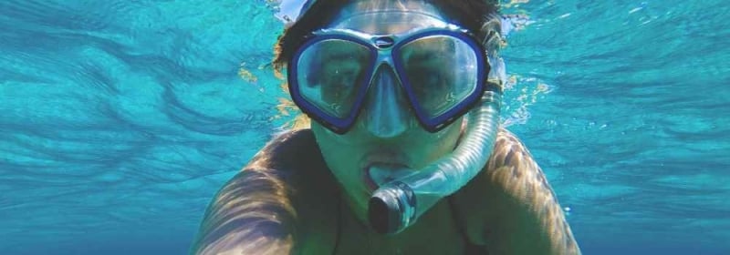 Vrouw met snorkel en duikbril onder water