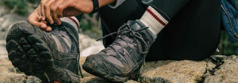 Vrouw met wandelschoenen op rots