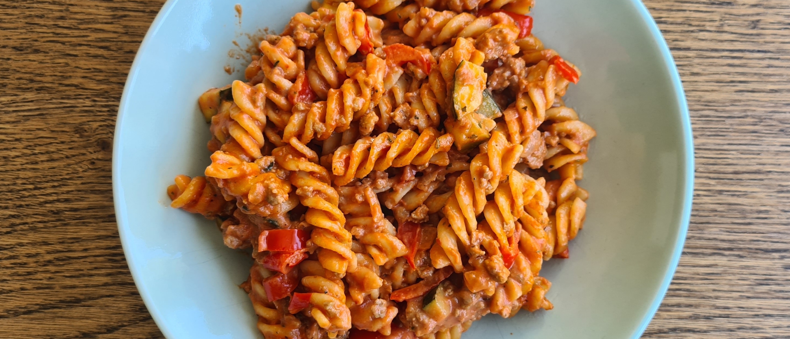 Simpele pasta met romige tomatensaus, gehakt, courgette en paprika