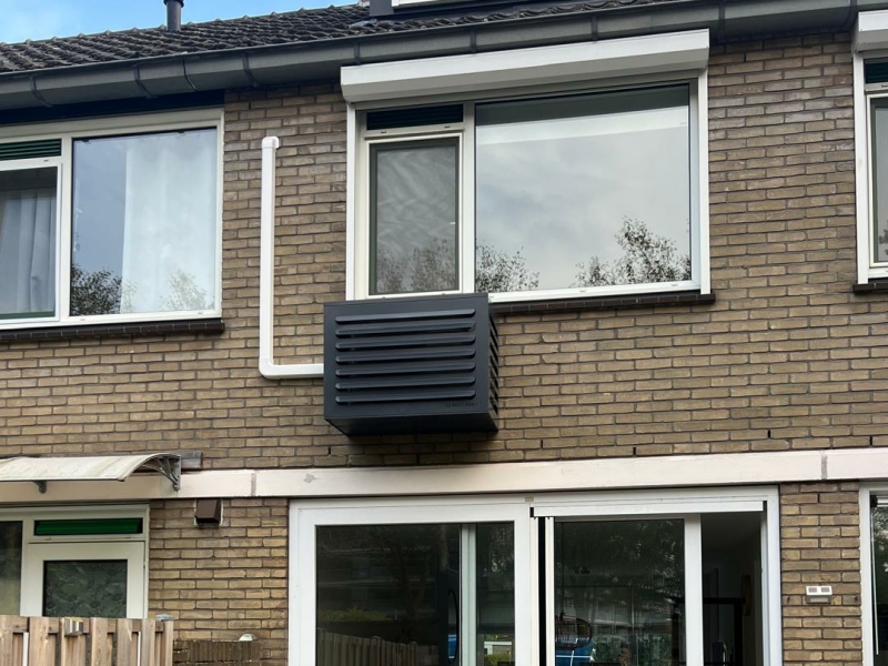 Airco-installatie voor woning – buitenunit met strakke montage Buitenunit van een thuisairco met nette leidinggoot op de achtergevel van een woning.