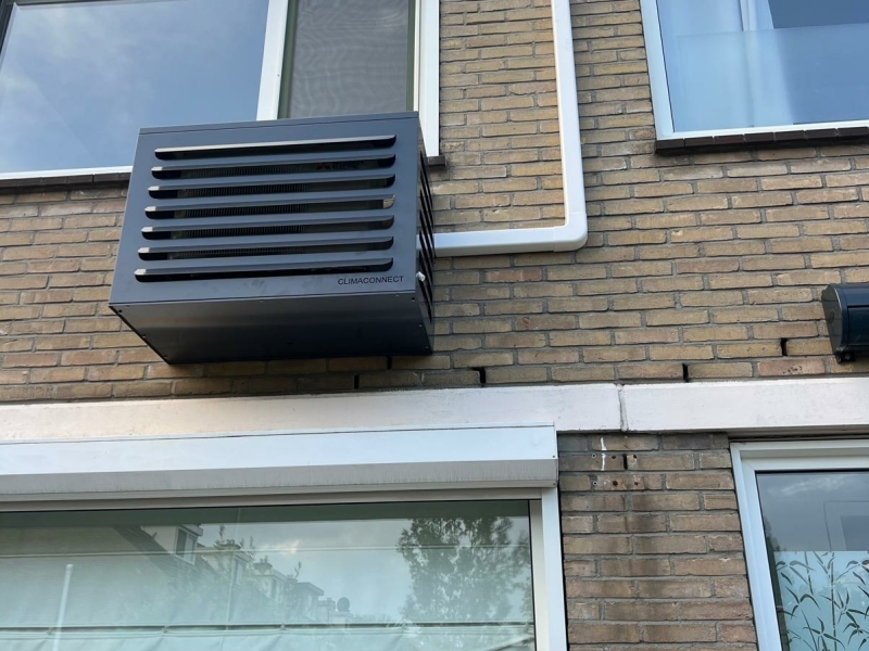 Airco voor thuis – buitenunit in luxe omkasting Buitenunit van een airco voor thuis, netjes weggewerkt in een zwarte omkasting aan een gevel.
