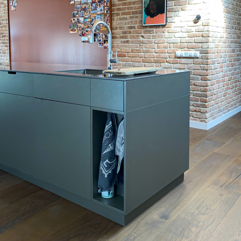 Custom towel storage cabinet designed to solve clutter issues in a kitchen