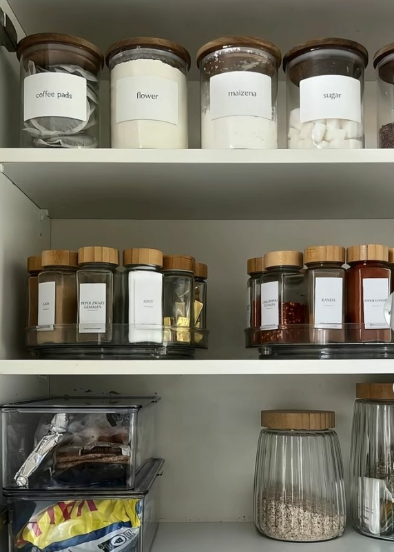 Glazen kruidenpotjes met houten deksel op een draaiplateau in een keukenkastje